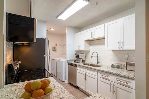 a kitchen with white cabinets and stainless steel appliances